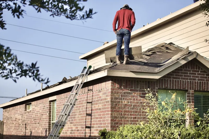 Professional roofer working on a residential roof in Draketown